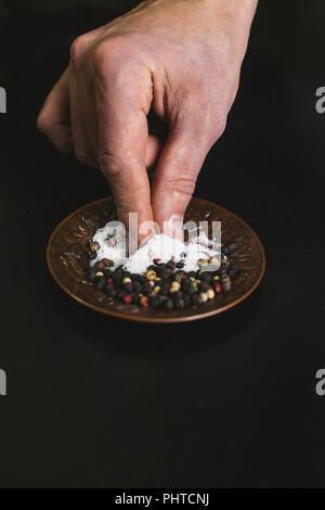 Un uomo prendendo un pizzico di sale Foto Stock