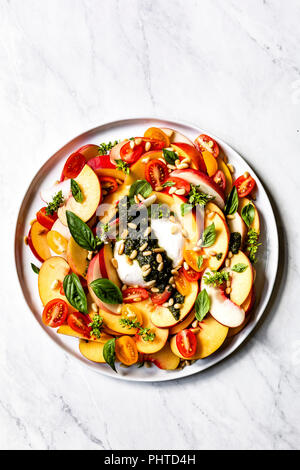 Burrata Caprese con pesche Foto Stock