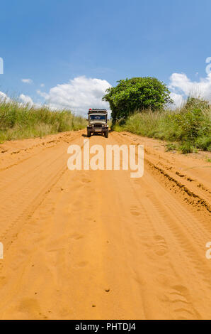 Vintage 4x4 di guida auto sulla sabbia rosso su strada sterrata in campagna della Repubblica Democratica del Congo. Foto Stock