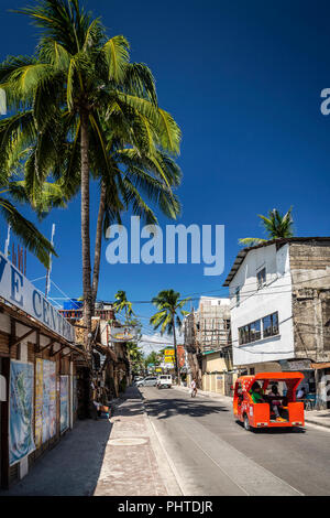 Un tuk tuk trike taxi il trasporto locale sulla strada principale nel centro di Isola Boracay Filippine Foto Stock