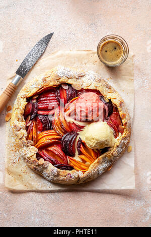 Pane appena sfornato frutta a nocciolo galette con due una cucchiaiata di gelato sulla parte superiore Foto Stock