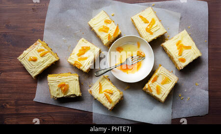 Pezzi di arancia e semi di papavero torta con una ciotola di frutta candita. Foto Stock