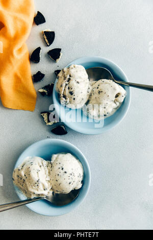 Biscotti al cioccolato gelato in due ciotole blu con un cucchiaio sul lato fotografata da vista dall'alto. Foto Stock