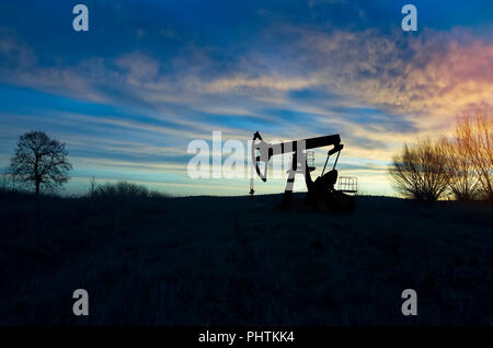 Operando il petrolio e il gas ben profilato sul Cielo di tramonto Foto Stock