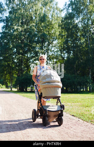 Donna che cammina con passeggino Foto Stock