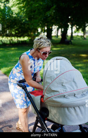 Donna che cammina con passeggino Foto Stock