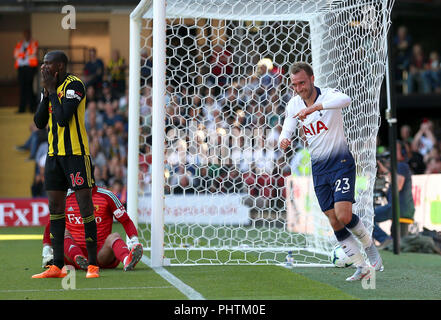 Tottenham Hotspur Christian Eriksen celebra il suo lato del primo scopo del gioco Lo scopo del gioco è venuta dopo un proprio obiettivo da Watford's Abdoulaye Doucoure (sinistra) durante il match di Premier League a Vicarage Road, Watford. Foto Stock