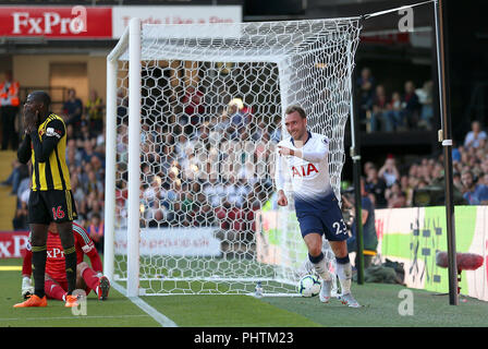 Tottenham Hotspur Christian Eriksen celebra il suo lato del primo scopo del gioco Lo scopo del gioco è venuta dopo un proprio obiettivo da Watford's Abdoulaye Doucoure (sinistra) durante il match di Premier League a Vicarage Road, Watford. Foto Stock