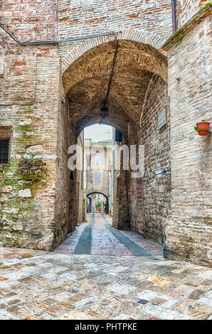 Passeggiando per le pittoresche e antiche strade di Assisi, una delle più belle città medievali in Italia centrale Foto Stock