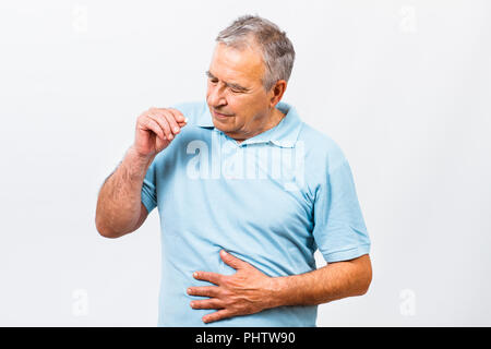 Senior uomo prendendo pillole per stomachache Foto Stock