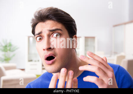 L'uomo nel panico perché di brufoli sulla pelle Foto Stock