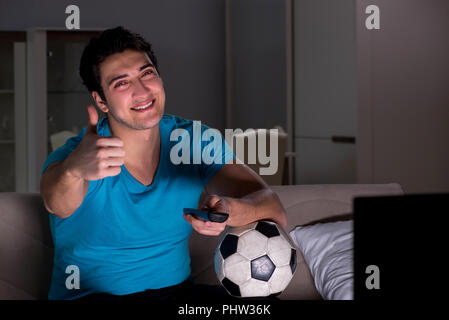 Giovane uomo guardando la partita di calcio a tarda notte Foto Stock