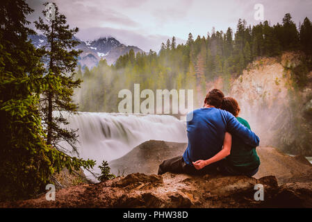 Un giovane seduto e ammirando la vista di ciò che rientra in Canada, BC Foto Stock