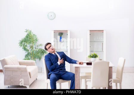 Imprenditore fallimento avente un attacco di cuore a casa Foto Stock