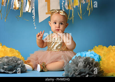 Studio shot, bambina su sfondo blu nel bellissimo vestito festivo Foto Stock