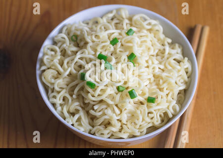 Plain tagliatelle in ciotola sul tavolo in legno con il fuoco selettivo Foto Stock