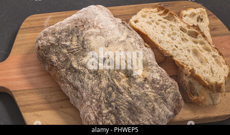 Pane e fette di pane in legno bordo - messa a fuoco selettiva su pane rustico close up Foto Stock