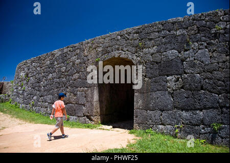 Visitatori uscire il cancello che conduce al reparto principale al Castello Zakimi rovine nel villaggio di Yomitan, Prefettura di Okinawa, in Giappone, il 20 maggio 2012. Costruito tra il 1 Foto Stock