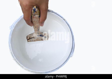 Mano che tiene un pennello a Stagno di vernice Foto Stock