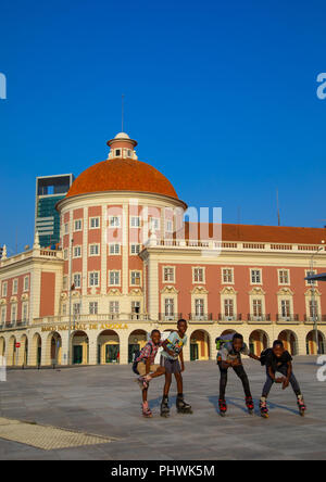 Angola ragazzi adolescenti wirth pattinaggio nella parte anteriore del banco nacional de angola, Provincia di Luanda, Luanda, Angola Foto Stock