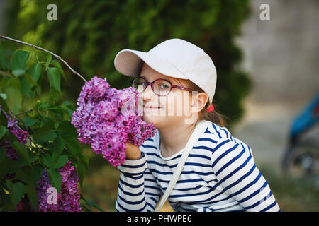 Ragazza profumati lillà fiori nel giardino. Messa a fuoco selettiva. Foto Stock