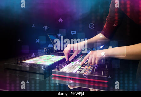 La miscelazione manuale musica sul controller DJ con i social media concetto icone Foto Stock