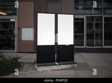 Due vuoto bianco lightboxes verticale in una città. Mock up di manifesti di strada. Foto Stock