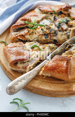 Galette con funghi e formaggio tagliato a pezzi. Foto Stock