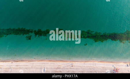 Vista aerea del mare onde che si infrangono sulla spiaggia senza persone. i riflessi del sole sull'acqua Foto Stock