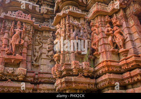 La parete esterna delle rovine di templi e splendidamente scolpito la scultura in pietra di indù e Jain la religione dal 15 D.C. al Polo della foresta nel Gujarat, India. Foto Stock