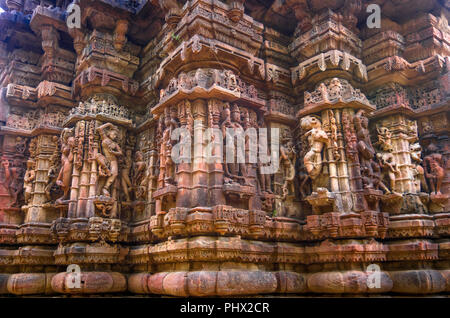 La parete esterna delle rovine di templi e splendidamente scolpito la scultura in pietra di indù e Jain la religione dal 15 D.C. al Polo della foresta nel Gujarat, India. Foto Stock