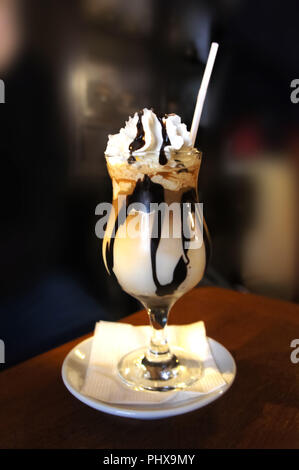 Frappé al cioccolato con sciroppo. Caffè ghiacciato in cima con panna montata. Bere caffè. Foto Stock