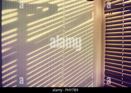 L'ombra dalla persiana sul muro bianco. Foto Stock