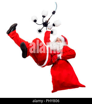 Funny Santa Claus si aggrappano lampadario con un sacchetto pieno di x-mas doni. La caduta di Santa trasportano il sacco con la confezione regalo. Foto Stock