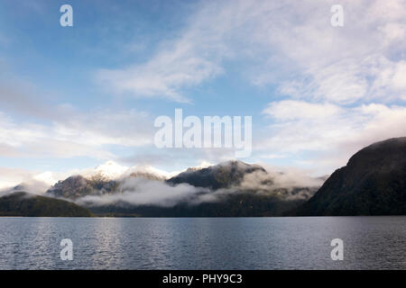 Vista sul paesaggio panoramico del Lago Manapouri, sull'Isola del Sud della Nuova Zelanda. Acqua, cielo e le montagne sono gli ingredienti per una splendida esperienza Foto Stock