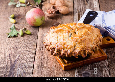 La torta di mele in padella in ghisa su tavola in legno rustico, tradizionale autunno accogliente dessert Foto Stock