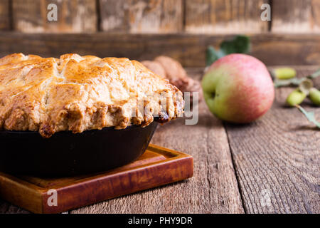 La torta di mele in padella in ghisa su tavola in legno rustico, tradizionale autunno accogliente dessert Foto Stock