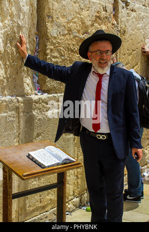 10 maggio 2018 un ebreo ortodosso maschio in un tradizionale abito scuro e hat toccando il Muro Occidentale di Gerusalemme in Israele Foto Stock