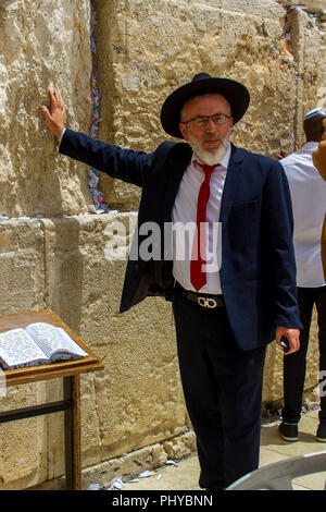 10 maggio 2018 un ebreo ortodosso maschio in un tradizionale abito scuro e hat toccando il Muro Occidentale di Gerusalemme in Israele Foto Stock