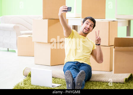 Giovane uomo bello in movimento per nuova casa con scatole Foto Stock