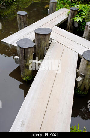 La foto mostra il percorso a zig-zag la passerella che conduce attraverso lo stagno del giardino Kakubuen al Honma Museum of Art di Sakata, prefettura di Yamagata, Giappone, o Foto Stock