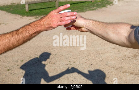 I corridori di afferrare un bicchiere di plastica di acqua durante la 10k l'esecuzione. Foto Stock