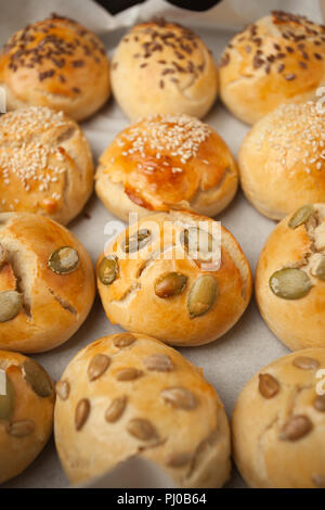 Freschi Fatti in casa Hamburger panini, brioche con sesamo, zucca, lino, semi di girasole sul vassoio, concetto di burger e cibo fatto in casa. Mini challah Foto Stock