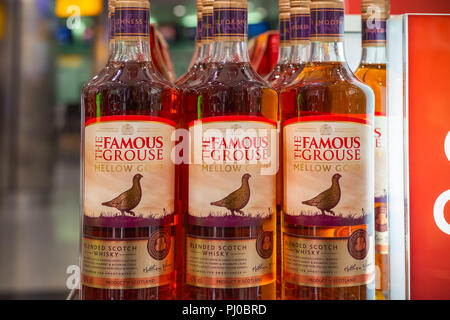 London, Regno Unito - 12 agosto 2018 - Bottiglie del Famoso Grouse, una marca di Scotch whisky blended sul display presso un negozio duty free a Londra Heathrow Airpor Foto Stock