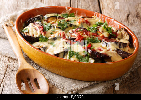 Pasto sano di melanzane al forno con pomodoro, erbe aromatiche e formaggio di close-up in una teglia su una tavola orizzontale. Foto Stock