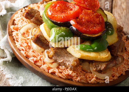 Medio Oriente Maklouba piatto o Makloubeh riso con carne e verdure close-up su una piastra su un tavolo. Posizione orizzontale Foto Stock