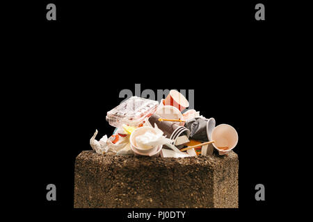 Close-up. Rifiuti domestici nel contenitore è isolato su uno sfondo nero. Foto Stock