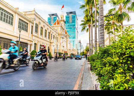 Ho Chi Minh, Vietnam - 30 Aprile 2018: Le Thanh Ton Street con Saigon City Hall, Vincom Center e sfocata bike il traffico. Il centro di Saigon Foto Stock