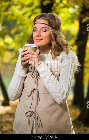 Bella ragazza boho gode di bere il caffè nel parco. Foto Stock