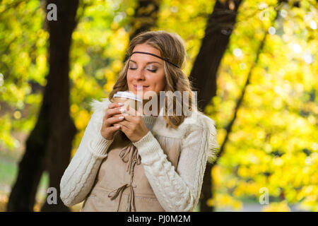 Bella ragazza boho gode di bere il caffè nel parco. Foto Stock